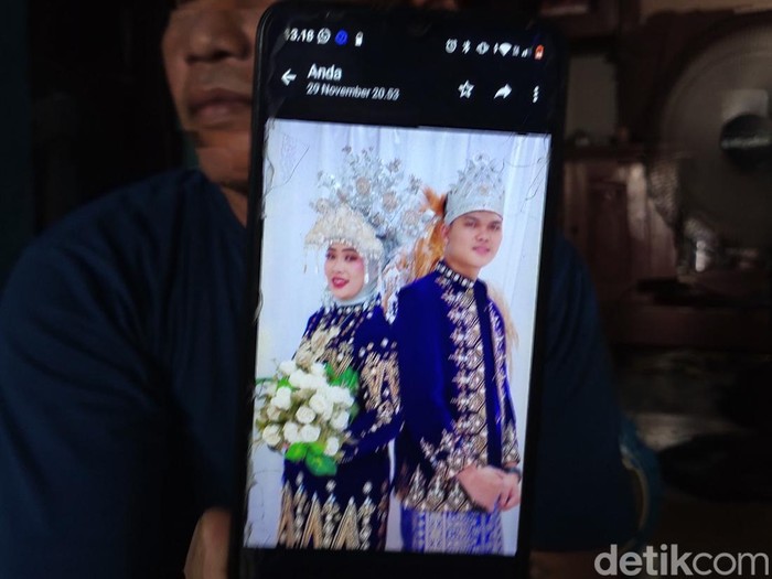 Paman Junita menunjukkan foto prewedding Junita dan Suparman.