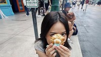 Penyanyi sekaligus aktris berusia 24 tahun ini punya momen seru ketika ngemil cookies saat sedang liburan di Universal Studios Singapore. Foto: Instagram @Hanggini