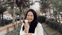 Ngemil es krim ketika berlibur di Eropa, Hanggini berpose dengan senyuman lebarnya yang manis. Foto: Instagram @Hanggini