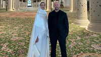 Dengan memakai pakaian tertutup, pasangan ini berpose di masjid. Jason mengenakan blazer dan celana berwarna gelap. Sedangkan istrinya memakai hijab berwarna putih yang dipadu dengan atasan tunik dan celana panjang lebar yang serasi.