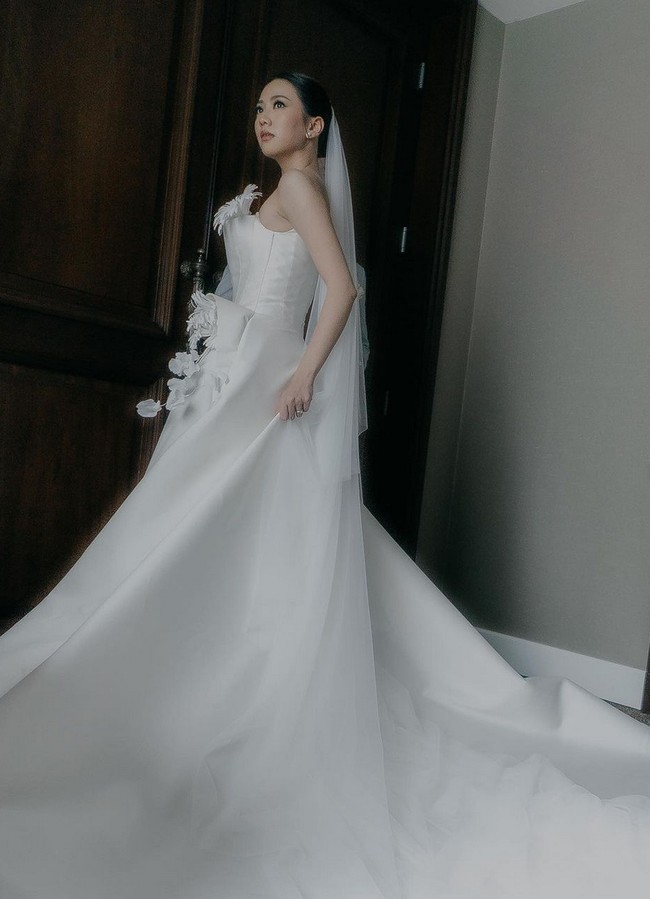 Gaun dengan ekor panjang menyapu lantai ini merupakan rancangan Elsie Chrysila Atelier. Mengusung konsep minimalis dan tak lekang waktu, gaun dirancang dengan siluet klasik A-line dengan sentuhan feminin. Foto: Instagram/@shanju @elsiechrysila