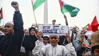 Massa membawa bendera dan poster untuk mendukung perjuangan Palestina melawan Israel. 
