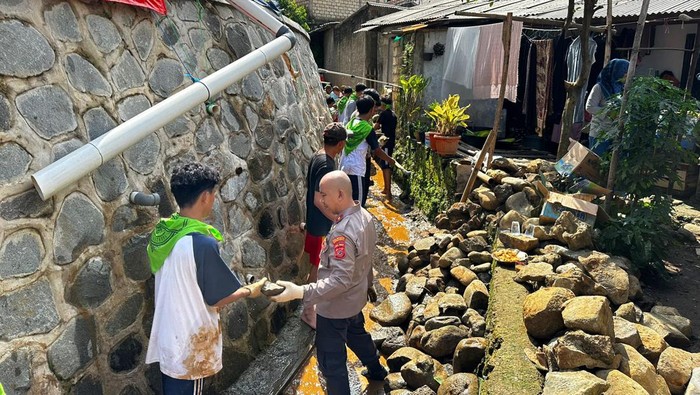 Puluhan pelajar SMA bersama dengan polisi kompak membersihkan saluran air hingga puing-puing di wilayah yang terdampak bencana longsor. (dok Ist)