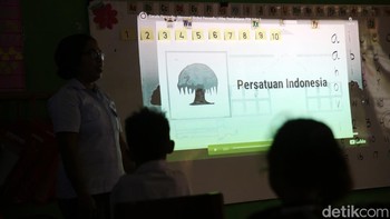 Seorang guru memberikan materi pelajaran kepada siswa-siswi SD Masehi Praiwora. 