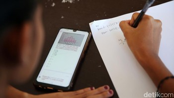 Seorang siswa sedang mengerjakan soal saat mengikuti UAS berbasis online.