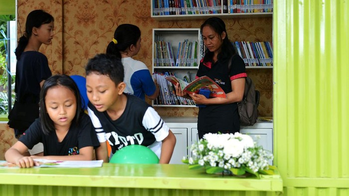 Pengunjung membaca buku koleksi Perpustakaan Semi-Kontainer di kawasan Taman Janggan, Denpasar, Bali, Minggu (3/12/2023). Perpustakaan yang memanfaatkan bangunan kontainer itu dibangun di titik keramaian untuk meningkatkan minat baca warga sekaligus sebagai upaya inovasi layanan untuk mendekatkan perpustakaan ke masyarakat. ANTARA FOTO/Fikri Yusuf/rwa.