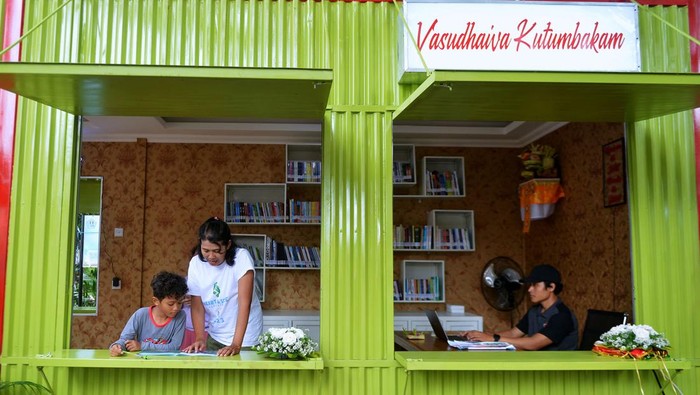 Pengunjung membaca buku koleksi Perpustakaan Semi-Kontainer di kawasan Taman Janggan, Denpasar, Bali, Minggu (3/12/2023). Perpustakaan yang memanfaatkan bangunan kontainer itu dibangun di titik keramaian untuk meningkatkan minat baca warga sekaligus sebagai upaya inovasi layanan untuk mendekatkan perpustakaan ke masyarakat. ANTARA FOTO/Fikri Yusuf/rwa.