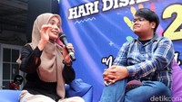 Siti Atikoh yang mengenakan baju hitam dengan hijab berwarna cokelat itu memberikan sambutan dalam acara peringatan Hari Disabilitas Internasional. 