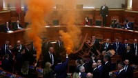 Flare berwarna oranye dinyalakan, kepulan asap langsung membumbung di ruang sidang.