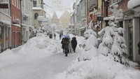 Orang-orang berjalan di jalan yang tertutup salju. AP/Christian Wiediger