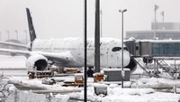 Sebuah pesawat Lufthansa diparkir di bandara Munich yang tertutup salju. Bandara Munich telah membatalkan semua penerbangan pada Sabtu (2/12), setelah badai musim dingin menyebabkan salju turun. AP/Karl-Josef Hildenbrand
