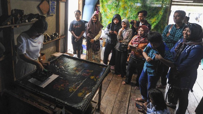 Serunya Rekreasi Sambil Belajar di Wisata Kerajinan Batik Jambi Wisatawan melakukan pengecapan kain batik saat mengikuti tur wisata batik di rumah produksi Saye Batik, Kuala Jambi, Tanjung Jabung Timur, Jambi, Minggu (3/12/2023). Tur wisata yang dibuka setiap Sabtu dan Minggu itu menyediakan beberapa cetakan motif batik khas setempat guna mengenalkan budaya membatik ke lebih banyak orang. ANTARA FOTO/Wahdi Septiawan/Spt.