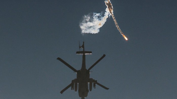 Israel Kembali Bombardir Gaza Setelah Gencatan Senjata Berakhir An Israeli military helicopter releases a flare over the Israel-Gaza border, after a temporary truce between Israel and the Palestinian Islamist group Hamas expired, as seen from southern Israel, December 1, 2023. REUTERS/Amir Cohen TPX IMAGES OF THE DAY