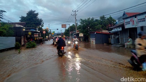 Suasana Banjir yang meluber ke jalan raya di Kelurahan Kandai 2, Kecamatan Woja, Senin (4/12/2023). (Faruk Nickyrawi)