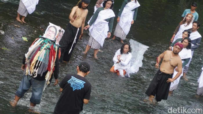 Komunitas budaya Patembayan Nusantara menggelar aksi dengan melarung keranjang sampah bergambar Politisi PSI Ade Armando di Kali Gajah Wong, Gambiran, Umbulharjo, Kota Jogja, Selasa (5/12).