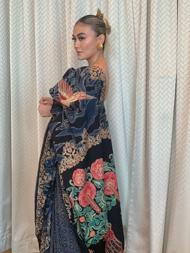 Selendang yang melengkapi busana tersebut menawarkan daya tarik tersendiri. Kain yang sudah eksis sebelumnya itu dihiasi motif berbentuk pohon hayat yang merupakan simbol dari Ibu Kota Negara (IKN) yang baru atau Nusantara di Kalimantan Timur. Motif tersebut menjadi sebuah pernyataan penting untuk menyatakan komitmen Indonesia dalam perannya mengatasi perubahan iklim. “60 persen paru-paru dunia ada di Indonesia,” katanya. Konsep Manunggaling kawulo gusti atau Bhinneka Tunggal Ika dalam filosofi Jawam tambah Era, juga disimbolkan dalam pohon hayat. (Foto: Dok. Era Soekamto)