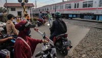 Pengendara kendaraan bermotor menerobos palang pintu rel kereta di perlintasan sebidang, Bojonggede, Kabupaten Bogor, Jawa Barat, Selasa (5/12/2023).