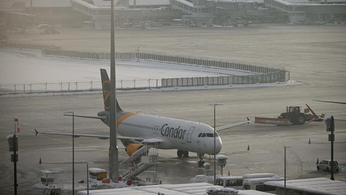 A tail fin of a Lufthansa plane is pictures behind snow at the terminal as Munich Airport has cancelled all incoming and outgoing flights until 12 p.m. (1100GMT) due to a forecast for sleet in Munich, Germany, December 5, 2023. Picture taken through a fence. REUTERS/Angelika Warmuth