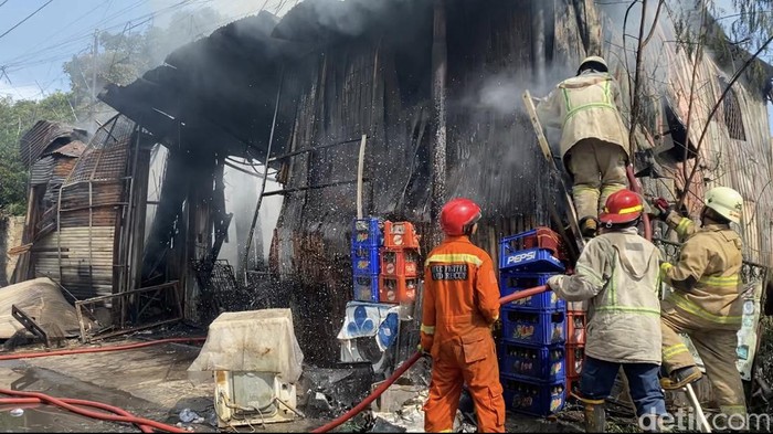 Damkar sempat kesulitan memadamkan kebakaran di lapak usaha besi tua di Beji, Depok. Damkar pun mencampur air dengan teepol untuk menyemprot api. (Devi Puspitasari/detikcom)