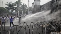 Mobil water cannon polisi dikerahkan ke depan gerbang DPR untuk menyiram api yang dinyalakan massa.