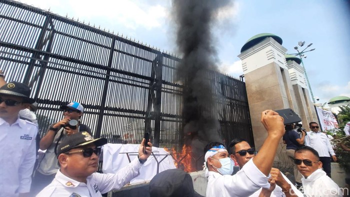 Massa dari Asosiasi Pemerintah Desa Seluruh Indonesia (Apdesi) menggelar demonstrasi di depan gedung DPR. Massa membakar spanduk dan ban. (Annisa AR/detikcom)