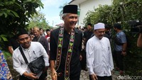 Calon presiden nomor urut 3 Ganjar Pranowo (tengah) berjalan dengan pengasuh Pondok Pesantren Syaichona Cholil, KH Muhammad Ali Cholil (kanan) saat tiba di Balikpapan, Kalimantan Timur, Selasa (5/12/2023).