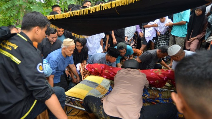 Momen Pilu Pemakaman Pendaki yang Tewas di Gunung Marapi Keluarga dan kerabat memakamkan jenazah korban erupsi Gunung Marapi di Bandar Buat, Padang, Sumatera Barat, Selasa (5/12/2023). Warga Padang Muhammad Alfikri (19) menjadi salah satu korban meninggal akibat erupsi Gunung Marapi pada Jumat Minggu (3/12/2023) dan termasuk dalam rombongan 14 mahasiswa Politeknik Negeri Padang (PNP) yang mendaki gunung itu dan sebagian belum dievakuasi. ANTARA FOTO/Iggoy el Fitra/wpa.
