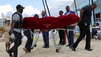 Petugas mengangkut jenazah seorang turis wanita setelah apa yang digambarkan polisi sebagai serangan hiu yang fatal di perairan dekat resor Sandals Royal Bahamian, di Nassau, Bahamas, Minggu (4/12/2023).  