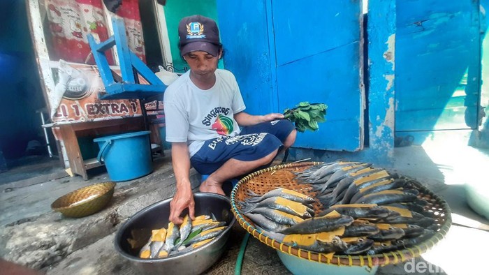 Pengrajin Ikan Pindang, Endang Suhendi (51) usai membersihkan ikan pindah di depan kediamannya.