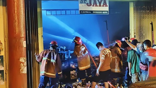 Petugas Damkartan Karangasem memadamkan api yang membakar sebuah ruko dan menghanguskan dua sepeda motor di Jalan Kesatrian, Karangasem, Bali, Senin malam (4/12/2023). (Dok. Damkartan Karangasem)