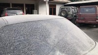 Abu vulkanik memenuhi beberapa mobil yang terparkir di Nagari Lasi.