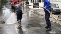 Damkar Agam berupaya membersihkan abu vulkanik yang memenuhi sepanjang jalan Nagari Lasi.
