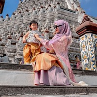 Kerap bergaya nyeleneh, potret Ria Ricis saat menggunakan kaca mata hitam terbalik sedang merapikan baju sang anak. Dalam keterangan unggahannya Ricis menulis, “Hidup kadang di atas kadang digidaw.” Foto: Instagram/@riaricis1795