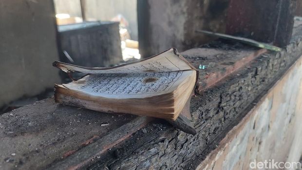 Warga sekitar Pasar Leces saat menunjukkan Al-Qur'an yang tetap utuh di tengah dahsyatnya kebakaran pasar