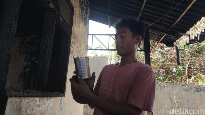 Warga sekitar Pasar Leces saat menunjukkan Al-Quran yang tetap utuh di tengah dahsyatnya kebakaran pasar