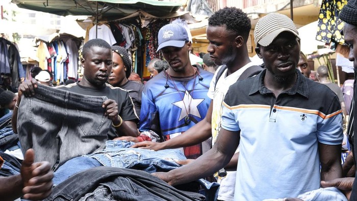Ugandans buy second hand clothes at Owino Market, in Kampala, Uganda, Friday, Sept. 15, 2023. Jostling for space, human bodies mingle in the crowded footpaths crisscrossing this expansive open market in the Ugandan capital. The marketgoers are mostly looking for second-hand clothing, from underwear that feels new between hands to shoes that customers try on while being pushed to make way for others. (AP Photo/Hajarah Nalwadda)
