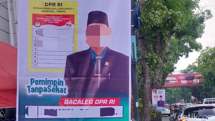 Ilustrasi caleg pasang alat peraga kapanye di pohon.