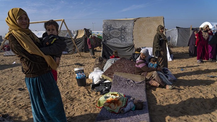 Palestinians displaced by the Israeli bombardment of the Gaza Strip gather at a tent camp, in Rafah, southern Gaza strip, Monday, Dec. 4, 2023. Hundreds of thousands of Palestinians have fled their homes as Israel moves ahead with a ground offensive against the ruling Hamas militant group. (AP Photo/Fatima Shbair)