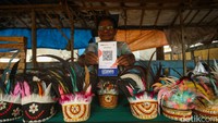 Anarumere menunjukkan scan Qris di lapak penjualan noken, Merauke, Papua Selatan, Jumat (17/11/2023). Perlu diketahui, kerajinan ini sempat hampir punah. Namun pada 2012, noken telah ditambahkan dalam Daftar Warisan Budaya Tak Benda yang Mendesak Perlu Dijaga atau Intangible Cultural Heritage List in Need of Urgent Safeguarding oleh UNESCO.