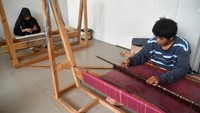 Pekerja menggunakan alat tenun bukan mesin (ATBM) untuk membuat kain dari limbah serat tandan kosong kelapa sawit di Kelurahan Situgede, Kota Bogor, Jawa Barat, Selasa (5/12/2023).
