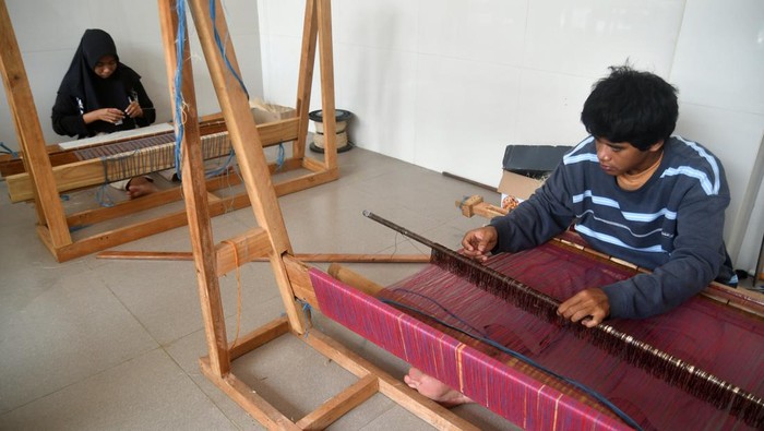Kreatif! Limbah Tandan Sawit Disulap Jadi Bahan Baku Fesyen Pekerja menggunakan alat tenun bukan mesin (ATBM) untuk membuat kain dari limbah serat tandan kosong kelapa sawit di Kelurahan Situgede, Kota Bogor, Jawa Barat, Selasa (5/12/2023). Peneliti IPB University dari Departemen Fisika, Fakultas Matematika dan Ilmu Pengetahuan Alam (FMIPA) Siti Nikmatin mengembangkan pengolahan limbah serat tandan kosong kelapa sawit menjadi produk bernilai ekonomi yang hasilnya mulai dari inovasi rayon viskosa (kapas buatan) sebagai bahan baku industri mode (fashion) hingga sepatu dan kain tenun. ANTARA FOTO/Arif Firmansyah/aww.