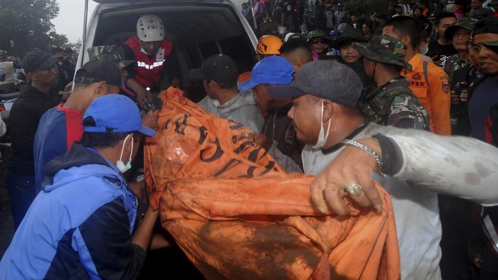 Rescuers carry the body of a victim of the eruption of Mount Marapi in Batu Palano, West Sumatra, Indonesia, Tuesday, Dec. 5, 2023. Rescuers searching the hazardous slopes of the volcano found more bodies of climbers who were caught by a surprise weekend eruption, raising the number of confirmed dead, officials said Tuesday. (AP Photo/Ardhy Fernando)