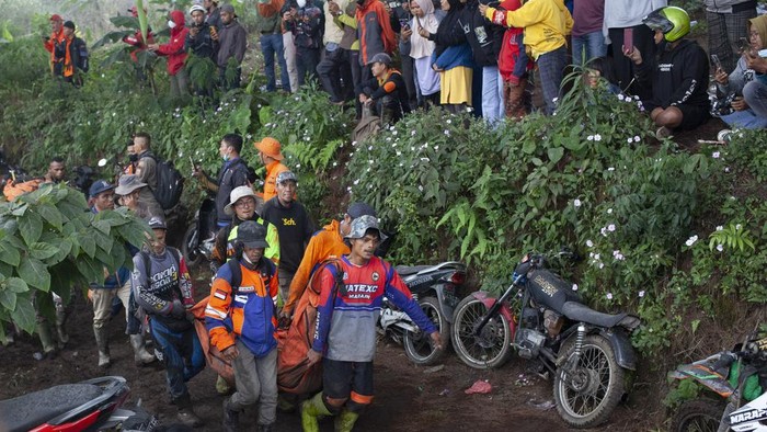 Momen Evakuasi Jenazah di Gunung Marapi, 23 Pendaki Tewas Rescuers carry the body of a victim of the eruption of Mount Marapi in Batu Palano, West Sumatra, Indonesia, Tuesday, Dec. 5, 2023. Rescuers searching the hazardous slopes of the volcano found more bodies of climbers who were caught by a surprise weekend eruption, raising the number of confirmed dead to nearly two dozens, officials said Tuesday. (AP Photo/Sigit Putra)