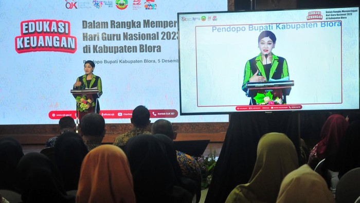 Kepala Eksekutif Pengawas Perilaku Pelaku Usaha Jasa Keuangan, Edukasi dan Pelindungan Konsumen Otoritas Jasa Keuangan (OJK) Friderica Widyasari Dewi (kiri) memberikan penjelasan kepada peserta saat kegiatan literasi dan edukasi keuangan di Pendopo Kabupaten Blora, Jawa Tengah, Selasa (5/12/2023). Kegitan literasi dan edukasi keuangan yang digelar OJK dalam rangka memperingati hari guru  dan diikuti ratusan guru itu mengambil tema waspada investasi dan pinjaman online ilegal. ANTARA FOTO/Yusuf Nugroho/aww.