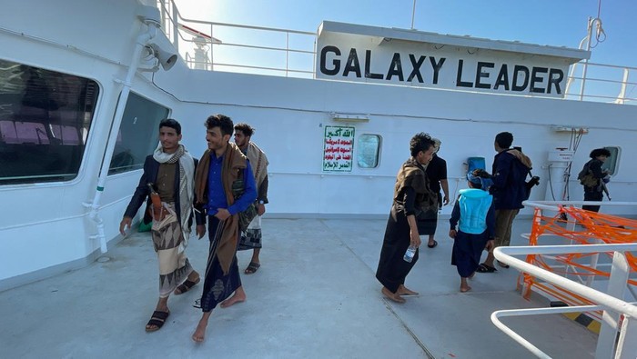 Pasukan Houthi 'Tur' di Kapal Israel yang Berhasil Dibajak People ride a boat near the Galaxy Leader commercial ship, seized by Yemen's Houthis last month, off the coast of al-Salif, Yemen December 5, 2023. REUTERS/Khaled Abdullah