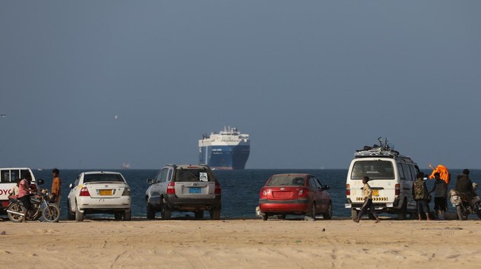 People ride a boat near the Galaxy Leader commercial ship, seized by Yemen's Houthis last month, off the coast of al-Salif, Yemen December 5, 2023. REUTERS/Khaled Abdullah
