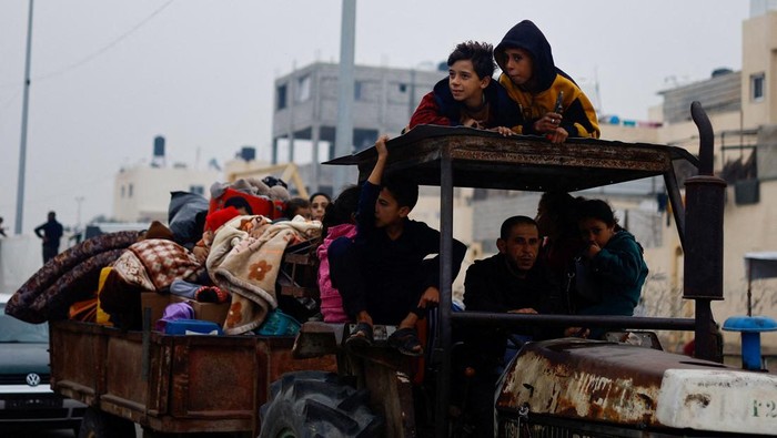 Pilu Warga Palestina, Hidup Serba Kekurangan di Tenda Pengungsian Palestinian boys sit on a tractor pulling a trailer as they flee their homes due to Israeli strikes, amid the ongoing conflict between Israel and Palestinian Islamist group Hamas, in Rafah in the southern Gaza Strip, December 5, 2023. REUTERS/Mohammed Salemβ¨β¨ TPX IMAGES OF THE DAY