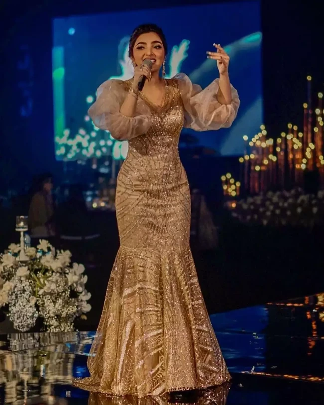 Jadi pengisi acara di salah satu pesta pernikahan, Ashanty memilih mengenakan dress model duyung dengan potongan lengan balon berwarna gold. Untuk mempercantik penampilannya Ashanty juga mengenakan beberapa aksesori penunjang seperti gelang, cincin, dan anting yang menjuntai di kedua telinganya. Foto: Instagram/@ashanty_ash