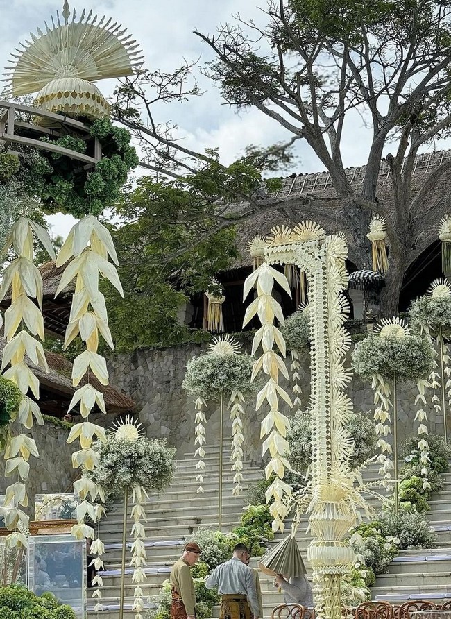 Di antara bunga-bunga putih seperti melati, lili, anggrek bulan dan babys breath, tergantung beberapa ornamen khas Bali yang memberi sentuhan etnik dan tradisional. Foto: Instagram/@stupacaspea @lxemoments