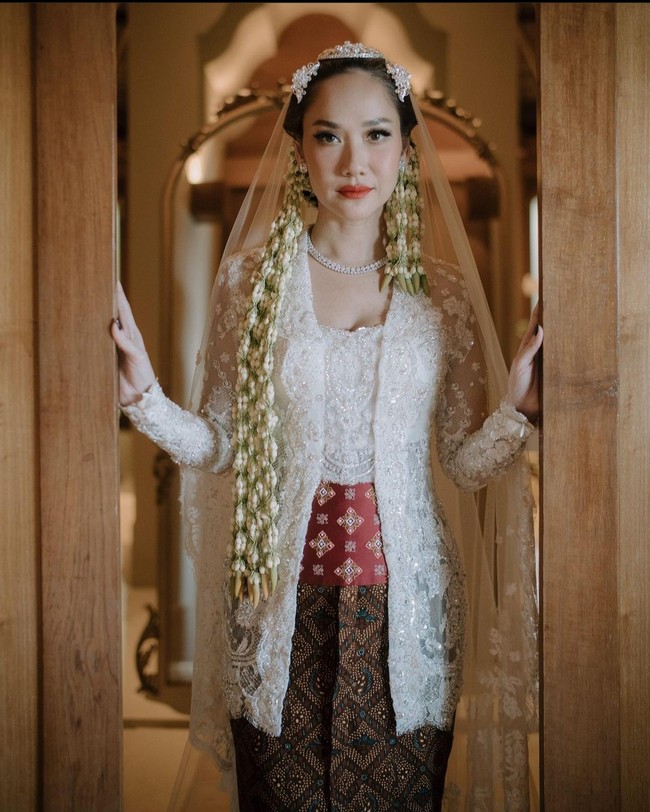 Model kebaya pengantin putih dari Bunga Citra Lestari ini bisa menjadi inspirasi. BCL melangsungkan pernikahan dengan Tiko Aryawardhana pada Sabtu (2/12/2023). Ia pun terlihat anggun dalam balutan kebaya pengantin putih karya Didit Maulana. Kebaya model kutubaru ini dilengkapi dengan obi merah, dan bawahan batik coklat. Foto: Instagram